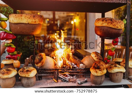 traditional Turkish Testi Kebab cooked in clay pot on open fire at night in restaurant, authentic oriental cuisine Royalty-Free Stock Photo #752978875