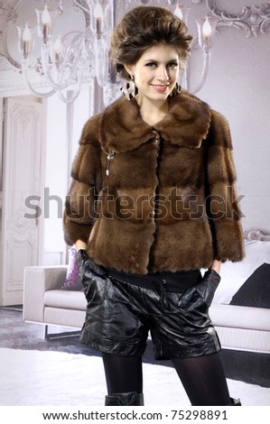 fashion model in autumn/winter clothes posing in the studio