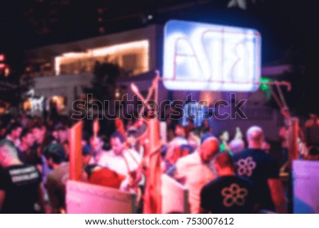 Blurred for background. Night club dj party people enjoy of music dancing sound with colorful light with Smoke Machine and lights show. Hands up in earth.