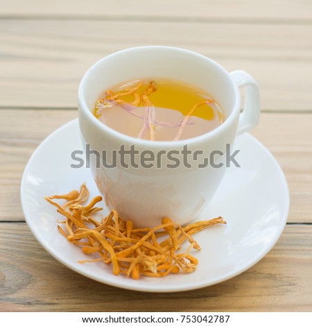 Dried Cordyceps Militaris Mushroom with Cup on wooden table background