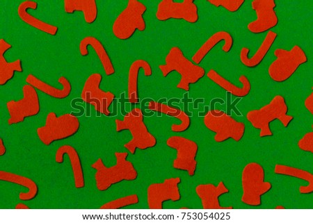 Red Christmas decoration on green background with different holiday shapes.   