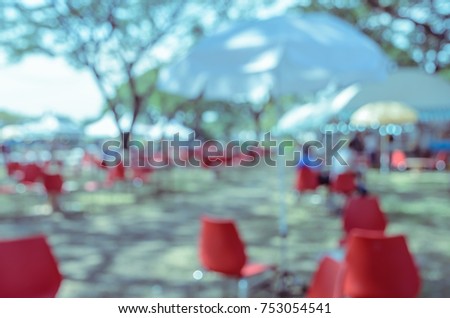Blurred image of a fair in green park. Abstract background for festival and market. Vintage filtered effect image