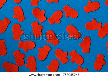 Red perforated paper Christmas holiday pattern shapes on a dark blue background.