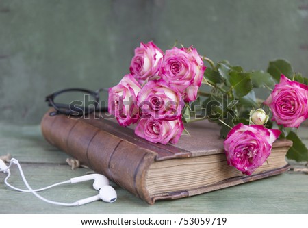 Vintage notebook mock up for artwork with pink roses. Place for text. Fresh flowers ans white headphones