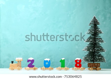 2018 happy new year,wooden toy train carrying numbers and Cristmas tree,covering snow