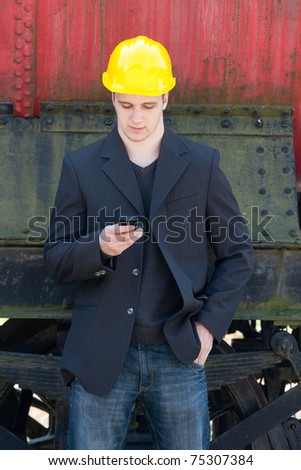 young engineer standing in front of old train