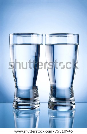 Two glasses of water on a blue background