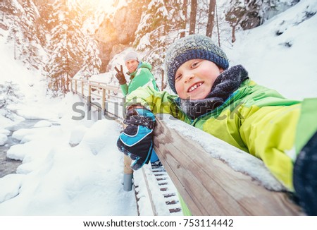 Boy take a selfie picture with his father in snow mountain canyo