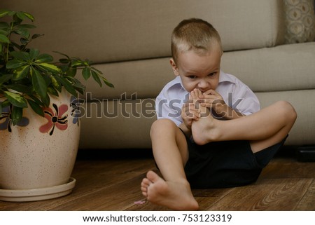 Little boy sitting on the floor and biting my toes, Christmas moments Royalty-Free Stock Photo #753123319