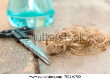 a scissors with strand of blonde hair