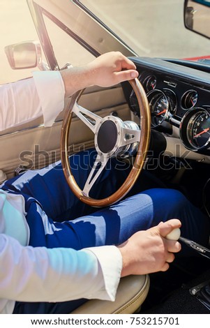 Sunny bright positive picture of a man driving car closeup