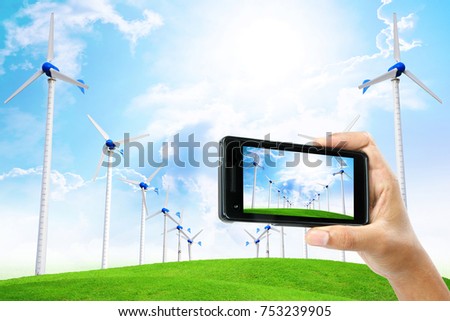 Male hand take a photograph by phone with wind turbine generator electricity background, Industry energy business concept.