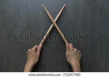 hand holding drum stick on black table background, music practice concept Royalty-Free Stock Photo #753247480