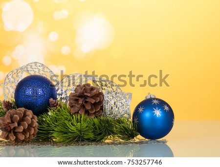 Bright New Year's toys-balls, silver ribbon and bumps, on yellow background