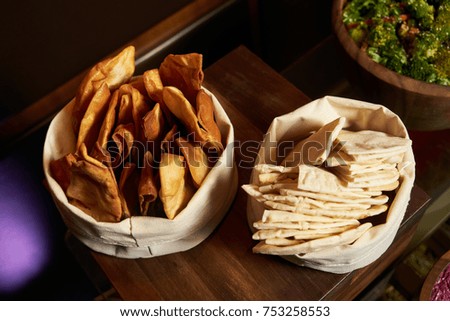 Diet pitta bread pieces in a white bag on wooden table, close-up, top view. Healthy vegetarian snack food 