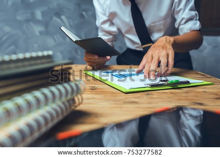 Young lawyer business man working hard top help his customer with messy paperwork on the old grunge wooden desk in loft style office workplace.