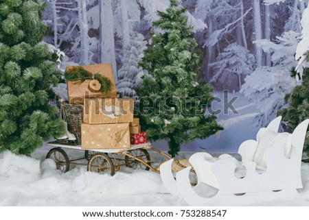 Decorated forest with fir trees, carriage and gift boxes. Christmas good mood. Design of New Year's studio