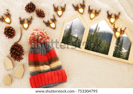 Houses shape wooden photo frames over cozy and warm fur carpet. Scandinavian style design. Top view