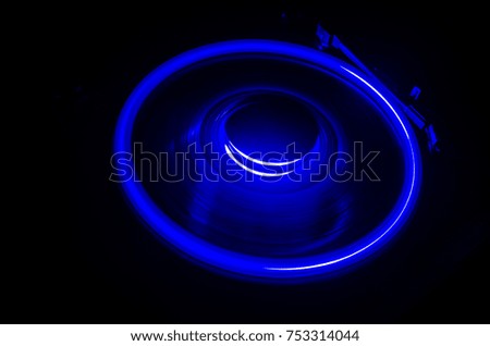 Turntable playing vinyl with glowing abstract lines concept on dark background