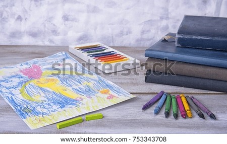 Child painting in the preschool with crayons
