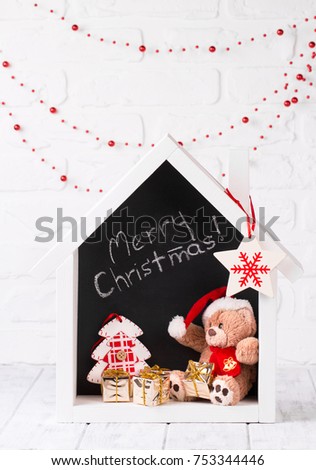christmas decoration with vintage toys: teddy bear, gift boxes and christmas tree in cozy dollhouse. retro style toned picture