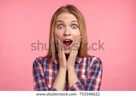 Portrait of excited female model has appealing appearace stares at camera with unbelievable gaze, suprised to recieve unexcpected gift from relatives. People, facial expressions, emotions concept Royalty-Free Stock Photo #753348622