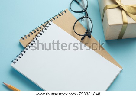 school notebook with gifts on a blue background, gift boxes with spiral notepad on the table