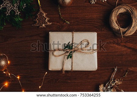 Christmas gift in a cozy atmosphere with decorations on a dark wooden background and a garland
