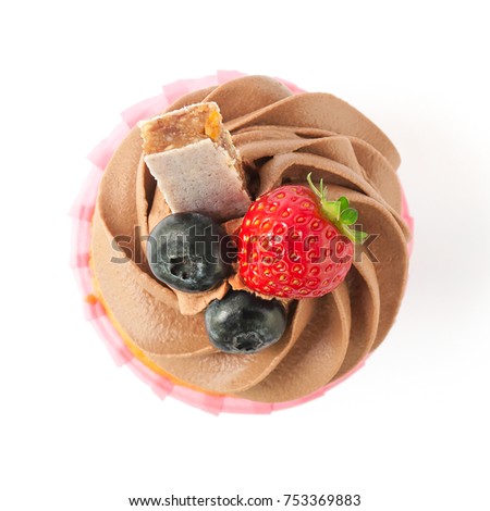 Pink cupcake with chocolate whipped cream decorated with strawberry, blueberry, granola bar isolated. Picture for a menu or a confectionery catalog. Top view.
