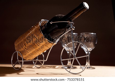 Dusty bottle of wine in a stand and glasses