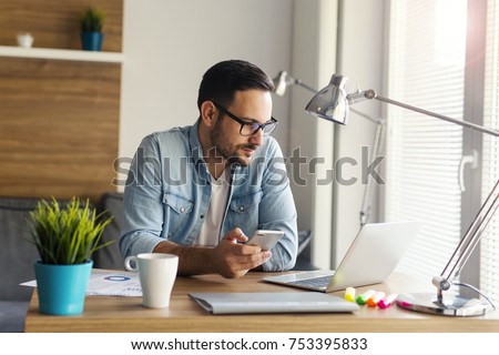 Freelancer working from home and using phone Royalty-Free Stock Photo #753395833