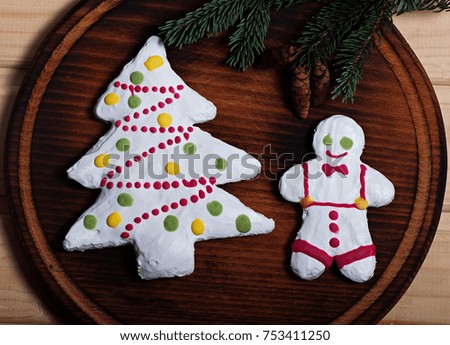 Composition of New Year's biscuits and fir branches on a wooden background, Christmas background. Christmas cookies.
