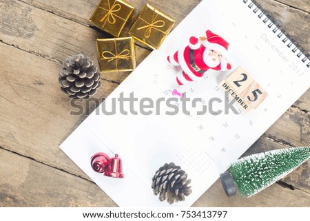 Christmas decoration with santa claus, pine cones and gift box on wood board.