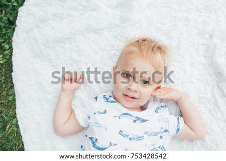 The small boy lying on the carpet in park