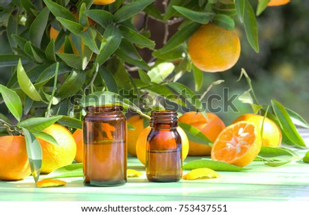 Tangerines with bottles of essential citrus oil. Spa background. Royalty-Free Stock Photo #753437551