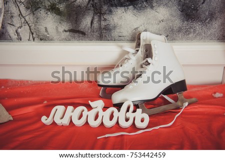 A pair of white skates and the word love.  Winter holiday. Winter sport
