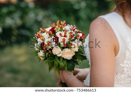 Charming and gentle bride keeps a beautiful wedding bouquet of roses. Wedding.