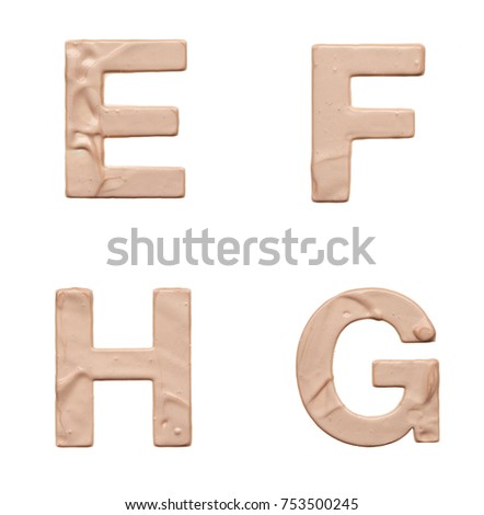 Stencil capital letters made from light beige creamy lipstick isolated on white background