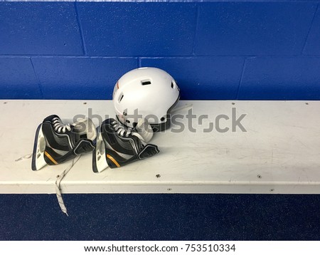 Child hockey skates and helmet in changing room