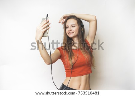 Woman in headphones,smile,selfie,in a short orange T-shirt