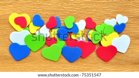Colorful hearts cutout on crepe paper background