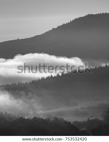 Early morning fog and mist between rolling hills in the Scottish Highlands
