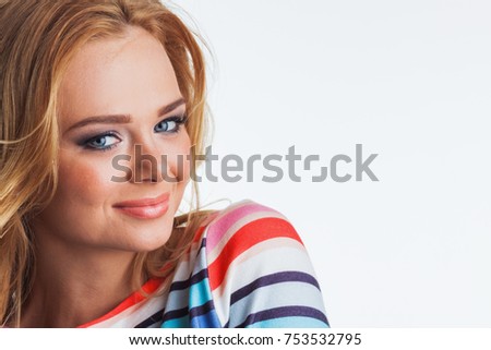 Portrait of happy girl with long blond curly hair wearing rainbow striped sweater
