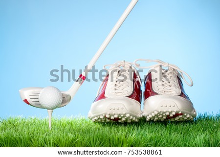Series of golfing equipment concept pictures.
Shot in studio on grass with blue background: Gold Shoes, Ball on Tee and Club