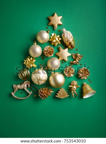 Christmas tree of gold color decorations on green paper background, top view