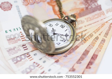 Money and clock on a chain on a white background. Time is money 