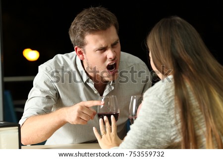 Angry couple arguing furiously in a bar at night Royalty-Free Stock Photo #753559732