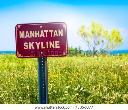 Oxymoron of a signpost for the Manhattan Skyline against a rural landscape