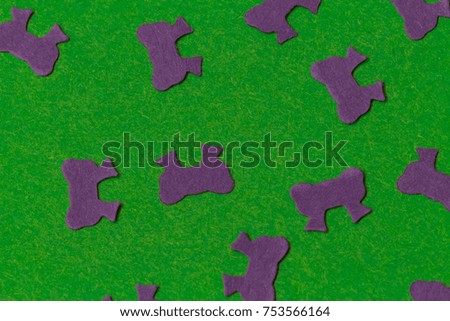 Purple perforated paper ribbons on a bright green background 