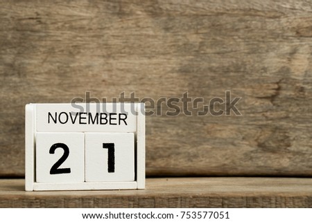 White block calendar present date 21 and month November on wood background
